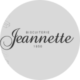 Logo de la Biscuiterie Jeannette, fondée en 1850, sur fond gris avec texte stylisé.