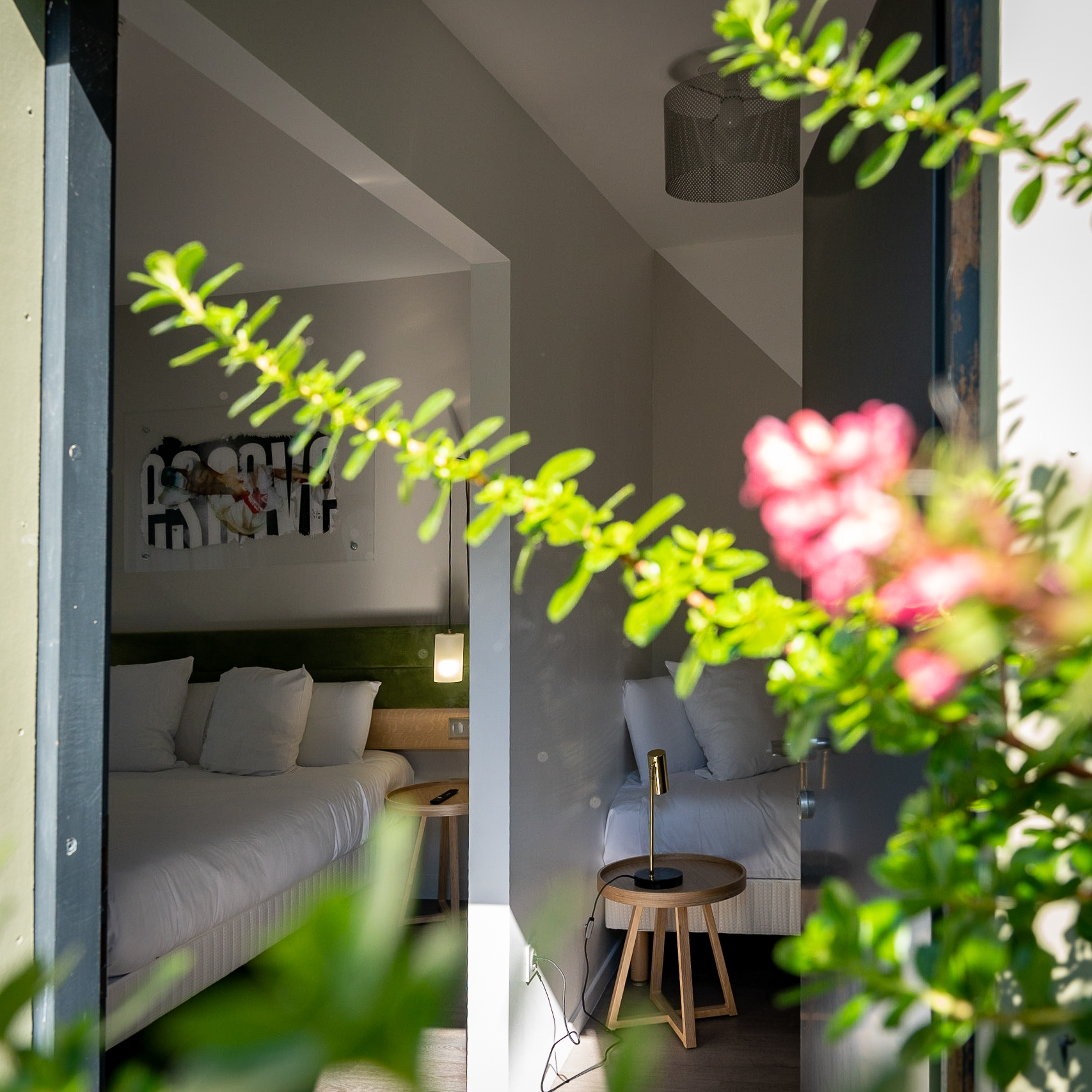 Vue sur une chambre moderne de l'Hôtel Libéra à Colombelles, avec décoration soignée et mobilier minimaliste.