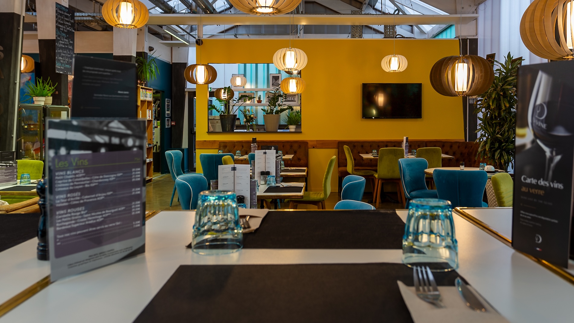 Intérieur moderne du restaurant de l'Hôtel Libéra, avec des tables élégamment dressées et des chaises colorées.